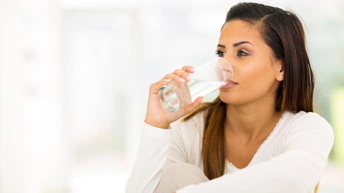 woman-in-white-shirt-drinking-water-with-eyebrow-up.jpg